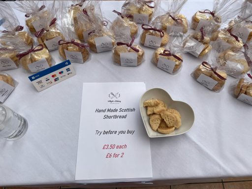 Whyte's Bakery Christmas Market Bags of cookies on a table with a sign inviting people to try them.