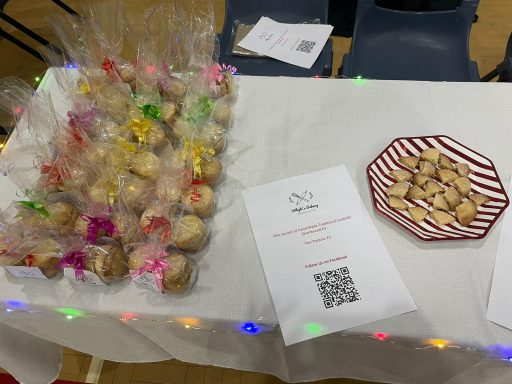 Whyte's Bakery Christmas Market A table with wrapped cookies and a plate of cookies, decorated with festive elements.