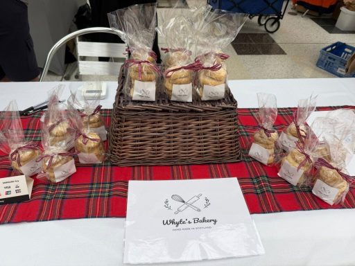 Whyte's Bakery Christmas Market A table display of packaged baked goods on a tartan tablecloth.